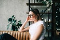 Young bored millennial woman sitting on a sofa alone at home. Fatigue or emotionally exhausted concept Royalty Free Stock Photo