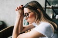 Young bored millennial woman sitting on a sofa alone at home. Fatigue or emotionally exhausted concept Royalty Free Stock Photo