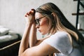 Young bored millennial woman sitting on a sofa alone at home. Fatigue or emotionally exhausted concept Royalty Free Stock Photo