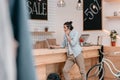 Young boutique owner talking on smartphone and using laptop indoors