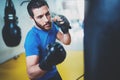 Young boxer doing some training on punching bag at gym. Bearded caucasian boxer training with punching bag in gym Royalty Free Stock Photo