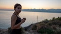 Young boxer girl posing by the sea over huge cliffs at sunset. She wears tights and sports bra Royalty Free Stock Photo