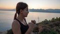 Young boxer girl posing by the sea over huge cliffs at sunset. She wears tights and sports bra Royalty Free Stock Photo