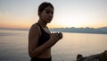 Young boxer girl posing by the sea over huge cliffs at sunset. She wears tights and sports bra Royalty Free Stock Photo