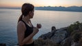 Young boxer girl posing by the sea over huge cliffs at sunset. She wears tights and sports bra Royalty Free Stock Photo