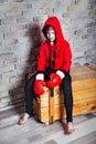 Little boy boxer with blonde hair dressing in red sweatshirt wearing boxing gloves posing in a studio. Royalty Free Stock Photo