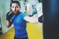 Young boxer man doing some training on punching bag at gym. Bearded caucasian boxer training with punching bag in gym Royalty Free Stock Photo