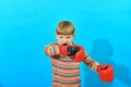 A young boxer puts gloves on his hands and helps to fasten them with his teeth, preparing a young athlete for a fight Royalty Free Stock Photo