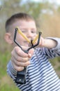 Young Boy Aiming Sling Shot Over Lake Royalty Free Stock Photo