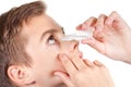 Young boy applying eye drop. On white background Royalty Free Stock Photo