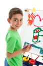 Young boy artist painting at easel