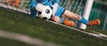 Young boy as a soccer goalie catching the ball during a soccer match. Football goalkeeper in jersey shirt Royalty Free Stock Photo