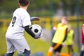 Young boy as a soccer goalie holding the ball in one hand ready to start a game. Football goalkeeper in jersey shirt Royalty Free Stock Photo