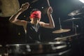 Young boy as rock band drummer . Handsome and cool Asian American teenager in headband playing drum kit performing night music Royalty Free Stock Photo