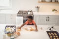 Young boy baking cookies in kitchen, rolling dough with concentration, copy space Royalty Free Stock Photo