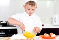 Young boy baking whipping eggs Royalty Free Stock Photo