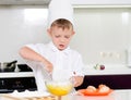 Young boy baking whipping eggs Royalty Free Stock Photo