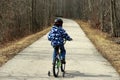 Young Boy on Bicycle with Training Wheels Learning to Ride Bike. Royalty Free Stock Photo