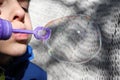 Young boy blowing bubbles from bubble maker close up view Royalty Free Stock Photo