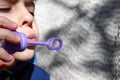 Young boy blowing bubbles from bubble maker close up view Royalty Free Stock Photo