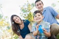 Young Boy Blowing Bubbles with His Parents in the Park. Royalty Free Stock Photo