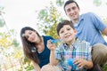 Young Boy Blowing Bubbles with His Parents in the Park. Royalty Free Stock Photo