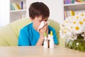 Young boy blowing nose with nazal sprays and other medication in Royalty Free Stock Photo
