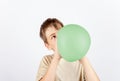 Young boy blowing a slime toy as if it would be a balloon