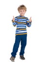 Young boy in blue pants holds his thumbs up