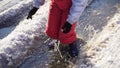 Boy in rainboots jumping in the ice puddle, slow motion