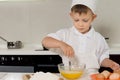 Young boy breaking eggs into a mixing bowl Royalty Free Stock Photo