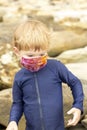 Young boy in a bright face mask playing in tidepools Royalty Free Stock Photo