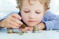 Young boy build a tower by coins. Royalty Free Stock Photo