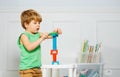 Young boy building block tower amidst books and toys Royalty Free Stock Photo