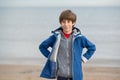 Young boy builds sand castle at the winter beach. Cute 11 years old boy at seaside, evening time. Royalty Free Stock Photo