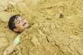 Young Boy Buried in Sand Royalty Free Stock Photo