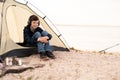 Young boy on camping trip.Child in a tent on beach listening music. Camping. Happy teen at spring vacations. Royalty Free Stock Photo