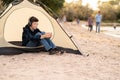 Young boy on camping trip.Child in a tent on beach listening music. Camping. Happy teen at summer vacations. travel Royalty Free Stock Photo