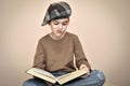 Young boy with cap reading an old book Royalty Free Stock Photo