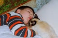 Young boy with cat resting on bed Royalty Free Stock Photo