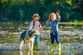 A young boy child and girl with dog playing outside in a river in the woods. Small boy and girl is playing with the dog Royalty Free Stock Photo