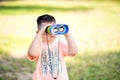 Young boy child playing pretend explorer adventure safari game outdoors with binoculars