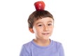 Young boy child with red apple fruit on his head healthy eating concept isolated on white Royalty Free Stock Photo