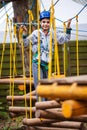 Young boy climbing pass obstacles in rope. Child in forest adventure park Royalty Free Stock Photo