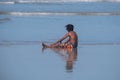 Young boy in colourful striped shorts plays in the waves at Port St Johns, Transkei, South Africa.