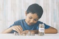 Young boy counting his coins/savings to buy dream toys. Royalty Free Stock Photo
