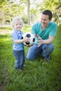 Young Boy and Dad Playing with Soccer Ball in Park Royalty Free Stock Photo