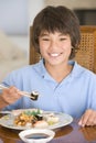 Young boy in dining room eating chinese food
