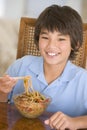 Young boy in dining room eating chinese food Royalty Free Stock Photo