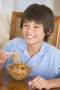 Young boy in dining room eating chinese food Royalty Free Stock Photo